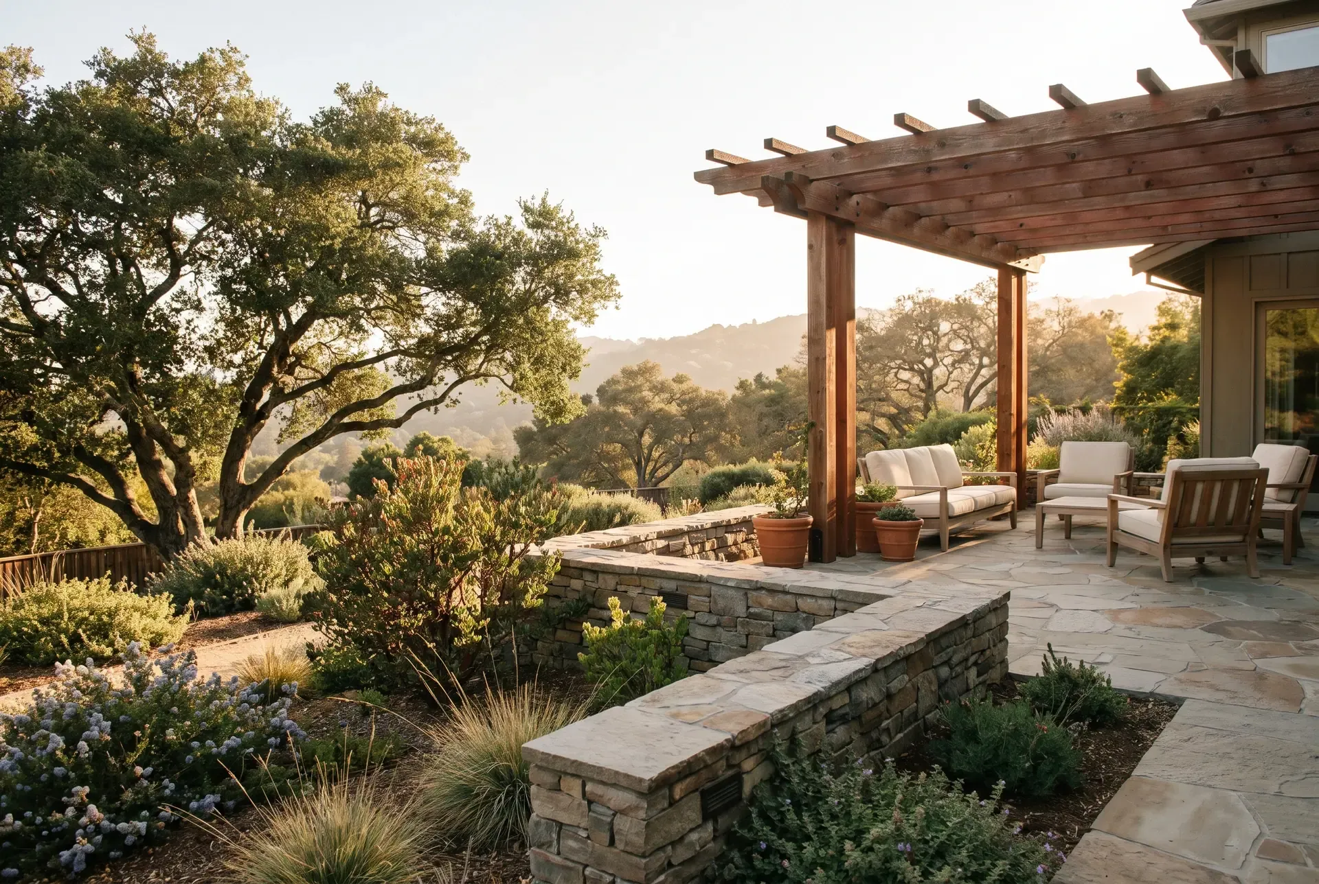 A terraced hillside backyard in Los Gatos with retaining walls, native oaks, and a patio overlooking a valley view