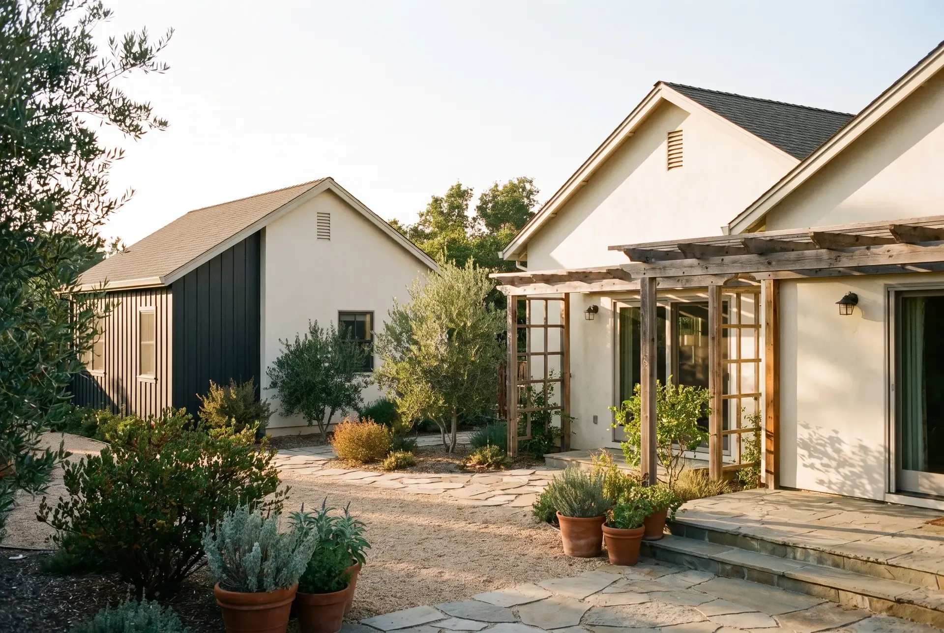 A single-family home with a detached ADU in the rear yard, both sharing matching roof lines and a cohesive coastal-California material palette
